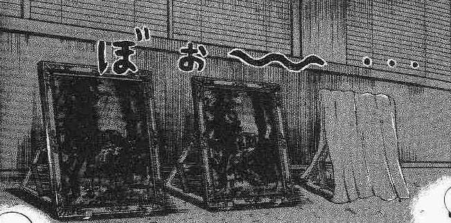 暗い部屋に並ぶ三枚の絵と、一枚を覆う布