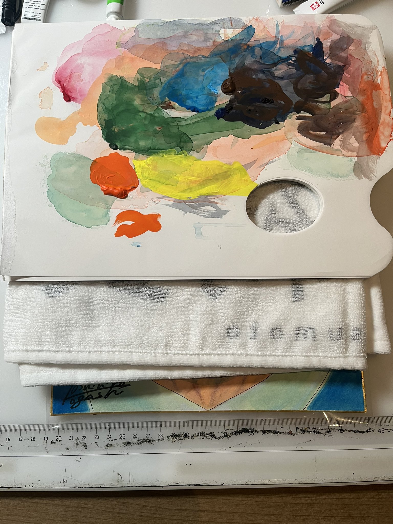 絵の具が残るパレットと、その下から一部が見える冨樫義博の依頼イラスト